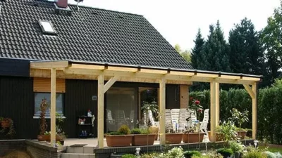 Terrassenüberdachung aus Holz vor Einfamilienhaus