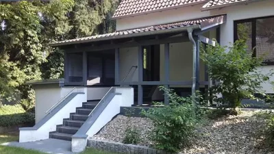 Holzüberdachung mit Ziegeldach vor modernen Einfamilienhaus